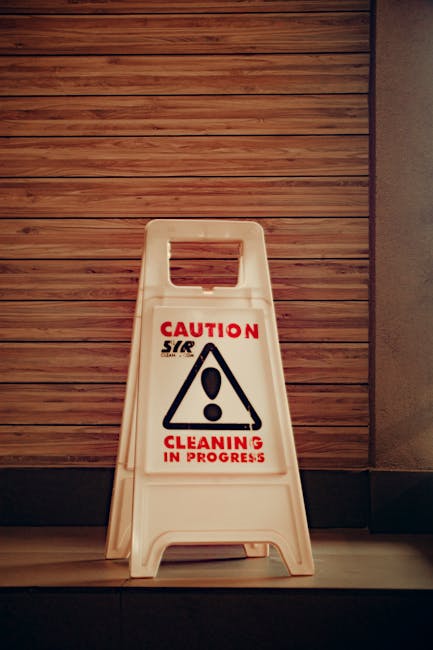 A close-up view of a clean wooden surface, possibly a tabletop or flooring, with a smooth and polished finish, well-lit with natural light highlighting the grain. In the background, a section of ceram